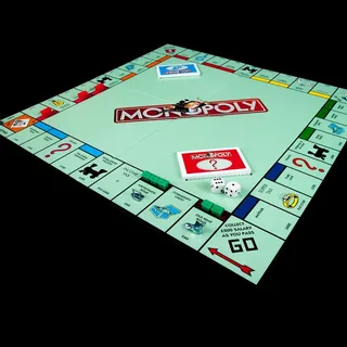 A Monopoly board game, set out with dice and cards